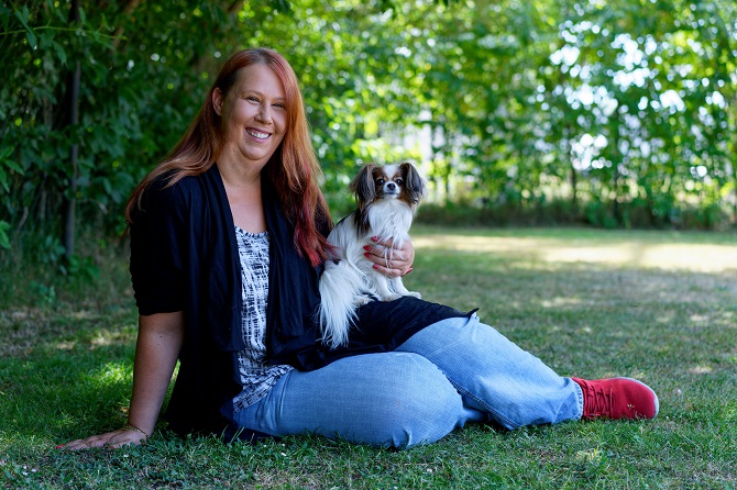 Hundetraining Franken - Team, Katy Sonderschefer mit Papillon sitzt auf Wiese