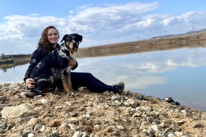 Hundetraining Franken - Praktikum, Aussiedor und Halterin sitzen am See
